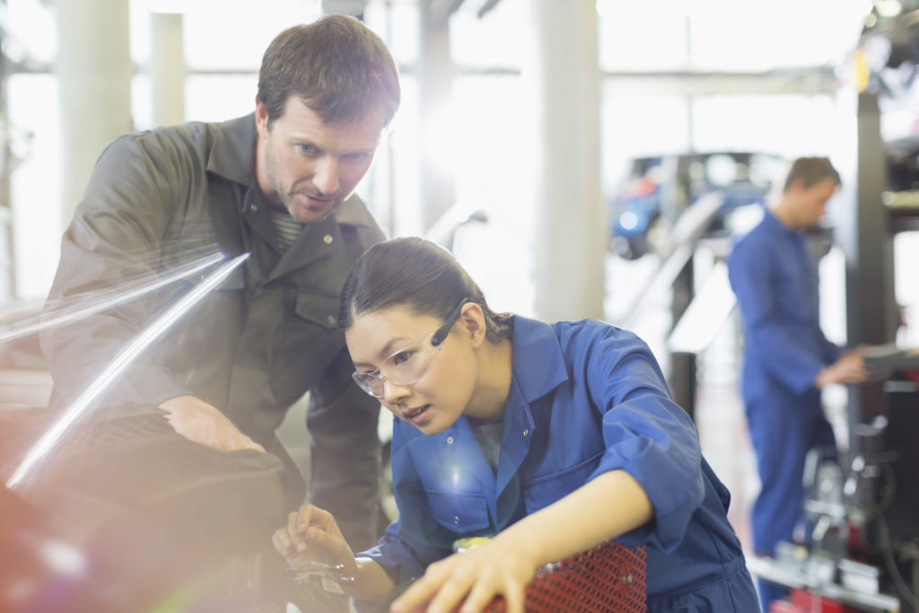 Hiring an apprenctice today is very diffferent to the way it used to be done. Here, a manager oversees a young female apprentice working with complex machinery.