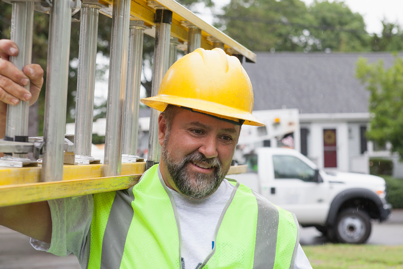 Electrician carrying ladder