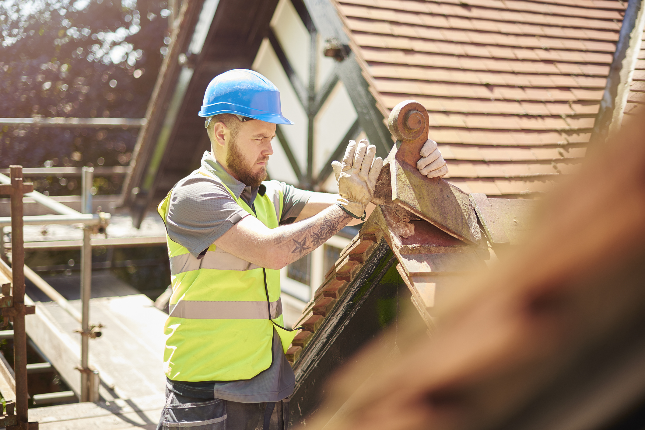 Roofer fixing tiles on roof