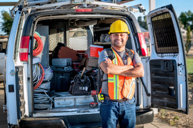 Mug shot of a Smiling hispanic construction worker wearing a work helmet looking at the camera